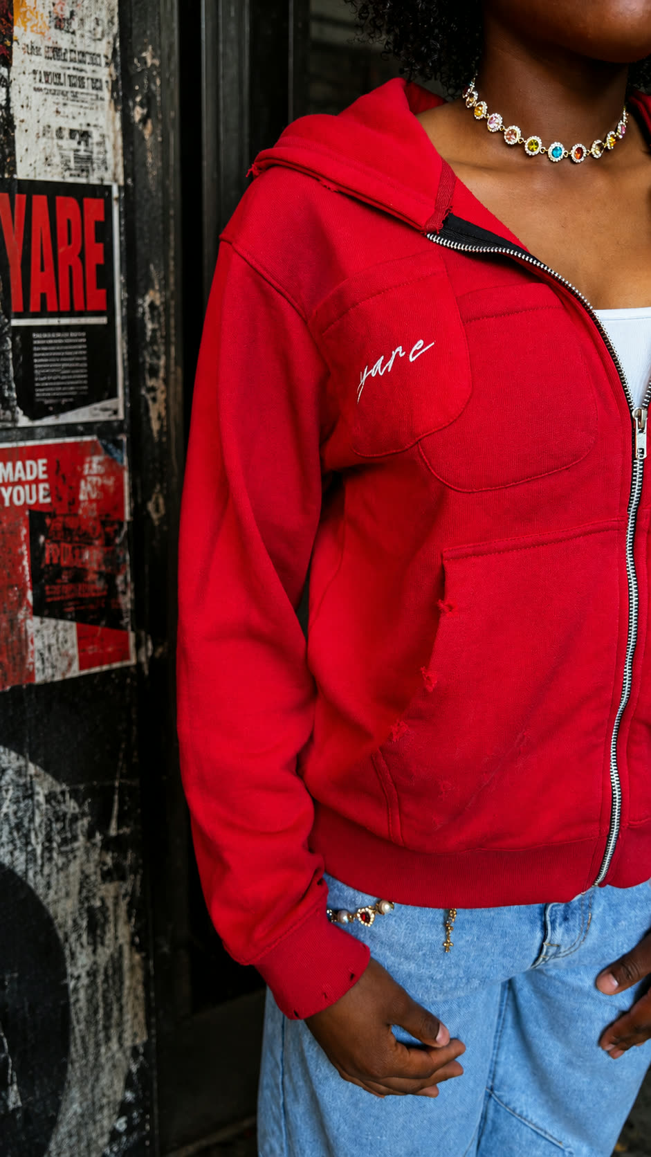 Close-up of a young woman wearing the red Double Pocket YARE Jacket